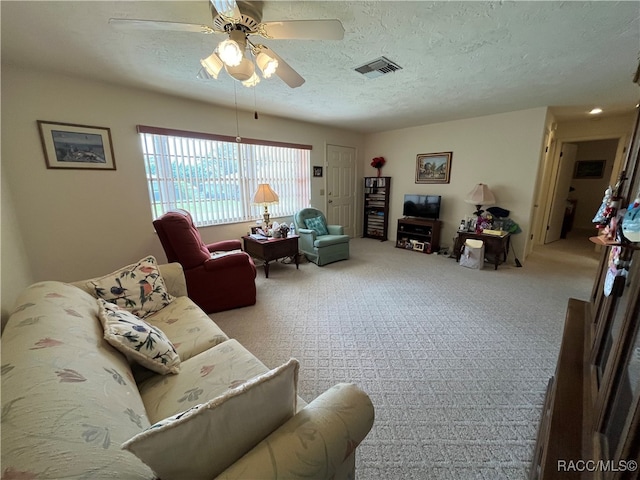 living room with light carpet, a textured ceiling, and ceiling fan