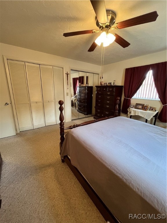 carpeted bedroom featuring ceiling fan and a textured ceiling