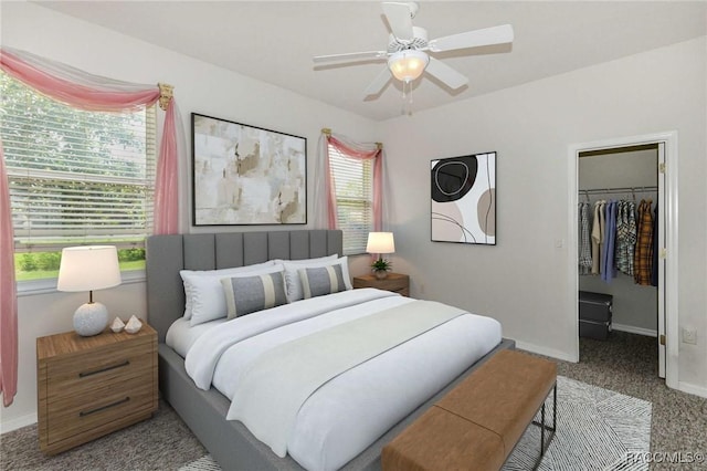 bedroom featuring a closet, a spacious closet, ceiling fan, and light colored carpet