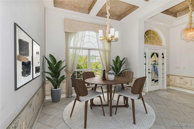 tiled dining room with beam ceiling, a high ceiling, coffered ceiling, and a notable chandelier