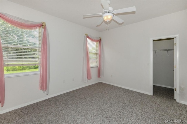 unfurnished bedroom with ceiling fan, a spacious closet, carpet floors, and a closet