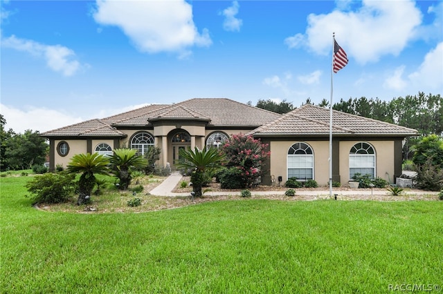 mediterranean / spanish-style house featuring a front lawn