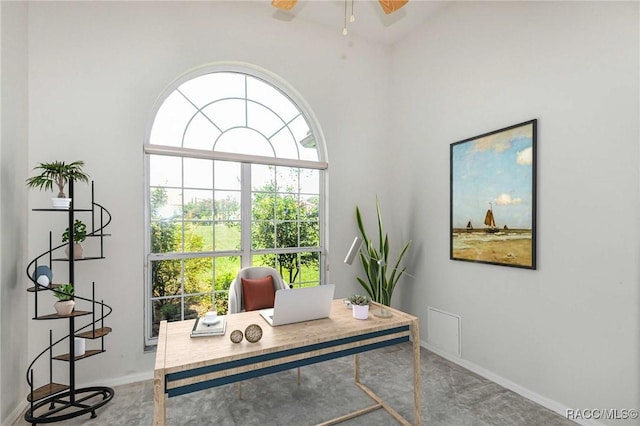 carpeted office space with ceiling fan