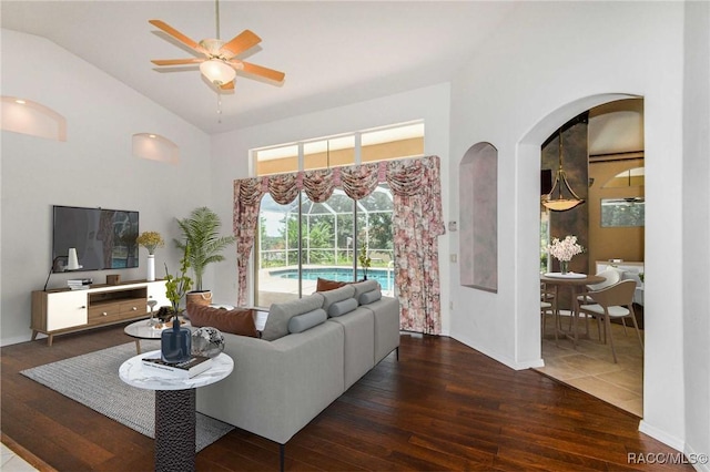 living room featuring dark hardwood / wood-style flooring, vaulted ceiling, and ceiling fan