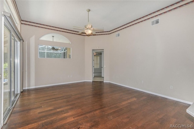 empty room featuring crown molding, ceiling fan, and dark wood-type flooring