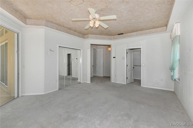 unfurnished bedroom featuring light colored carpet, a raised ceiling, and ceiling fan