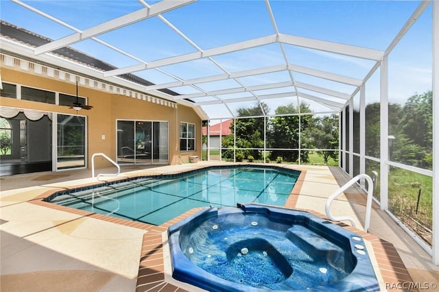 view of swimming pool with glass enclosure, ceiling fan, a patio area, and an in ground hot tub