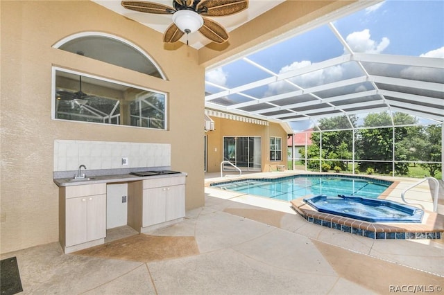 view of pool featuring an in ground hot tub, area for grilling, ceiling fan, glass enclosure, and a patio area