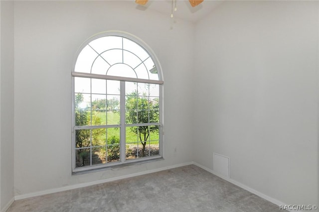 empty room featuring carpet, vaulted ceiling, and ceiling fan