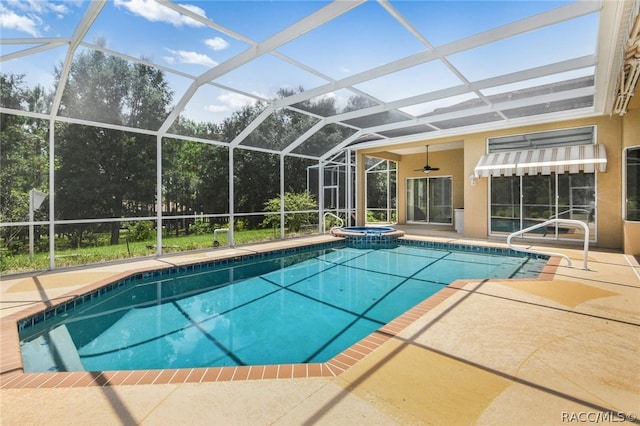 view of pool featuring glass enclosure, a patio area, and an in ground hot tub