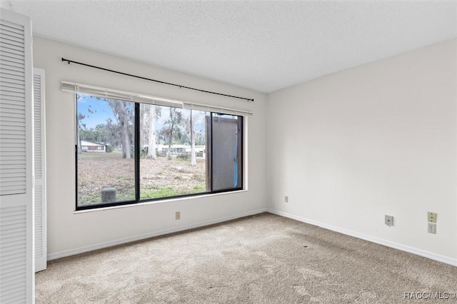 carpeted spare room featuring a textured ceiling