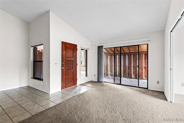 empty room with vaulted ceiling and carpet floors