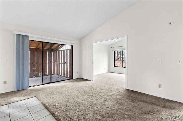 spare room featuring vaulted ceiling and light colored carpet