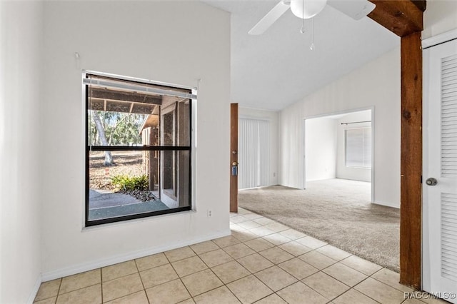 spare room with vaulted ceiling, light colored carpet, and ceiling fan