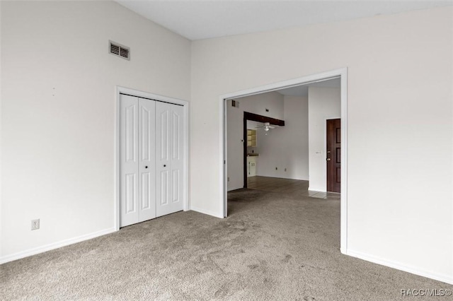 spare room featuring light carpet and vaulted ceiling