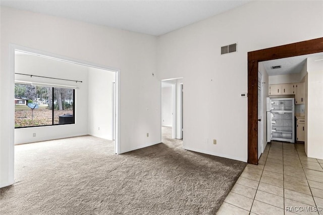 carpeted empty room with a towering ceiling