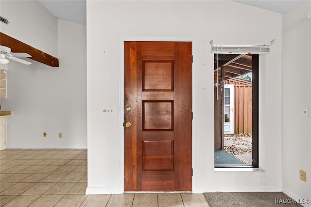 tiled entryway featuring lofted ceiling and ceiling fan