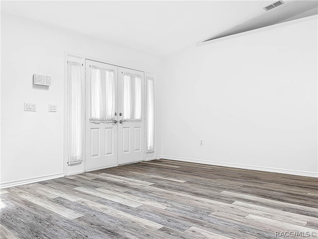 empty room featuring hardwood / wood-style floors and vaulted ceiling