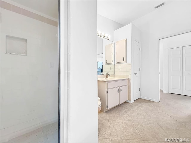 bathroom featuring tile patterned flooring, vanity, and a shower with shower door