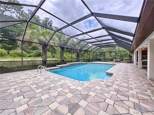 view of pool featuring glass enclosure and a patio area