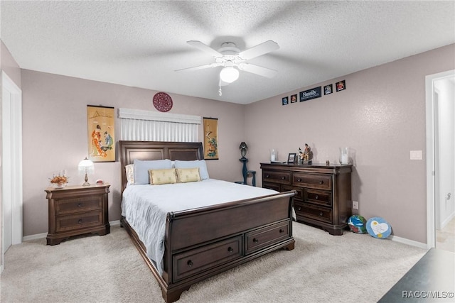 carpeted bedroom with ceiling fan and a textured ceiling