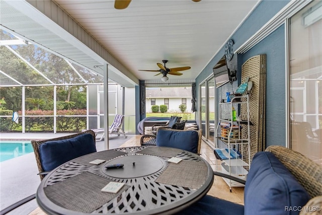 sunroom / solarium featuring a swimming pool, ceiling fan, and a healthy amount of sunlight