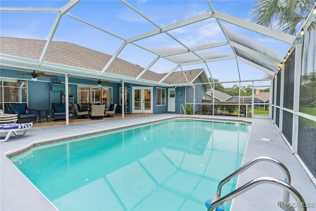 view of swimming pool with ceiling fan, a lanai, french doors, and a patio area