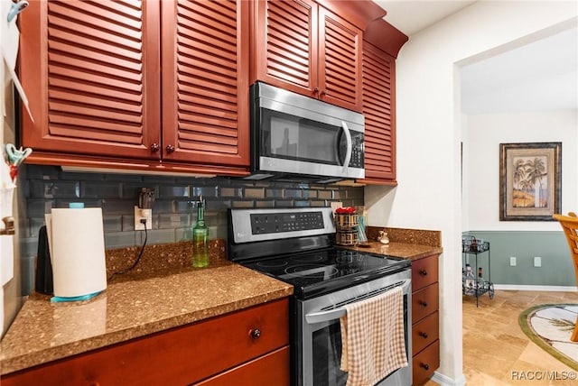 kitchen featuring stainless steel appliances, dark stone countertops, and backsplash