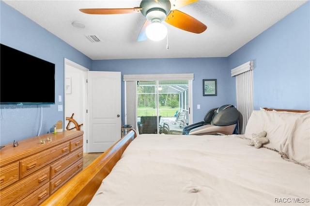 bedroom with hardwood / wood-style floors, access to exterior, ceiling fan, and a textured ceiling