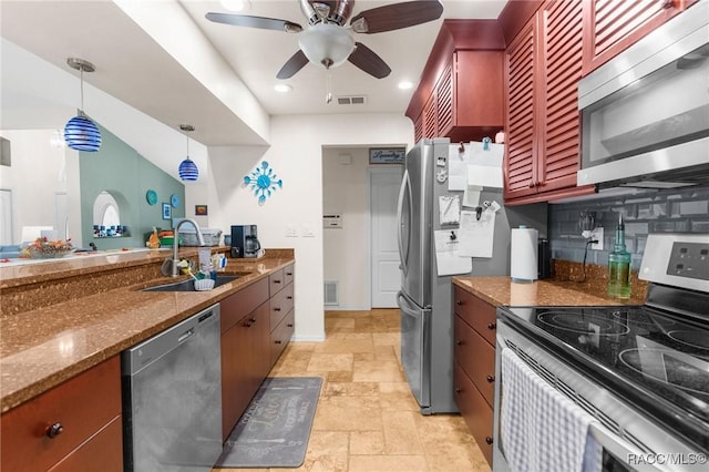 kitchen featuring appliances with stainless steel finishes, dark stone counters, pendant lighting, sink, and backsplash