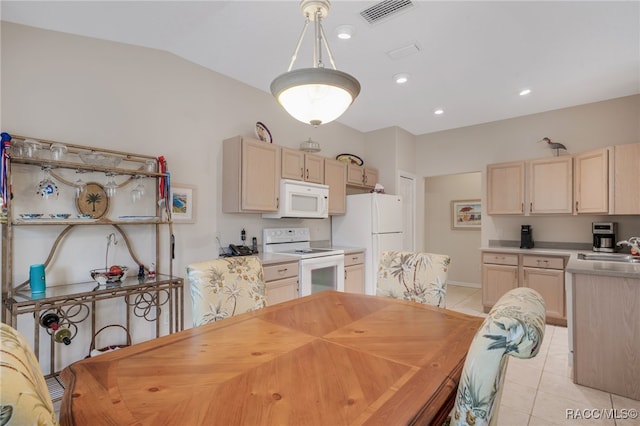 dining area featuring sink, vaulted ceiling, and light tile patterned flooring