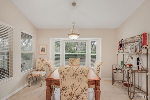 tiled dining room with vaulted ceiling and a healthy amount of sunlight