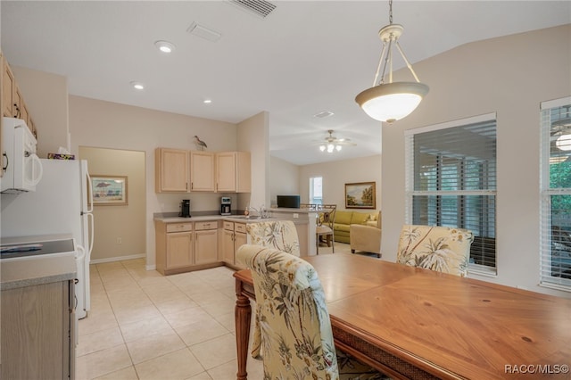 tiled dining area featuring ceiling fan, lofted ceiling, and sink