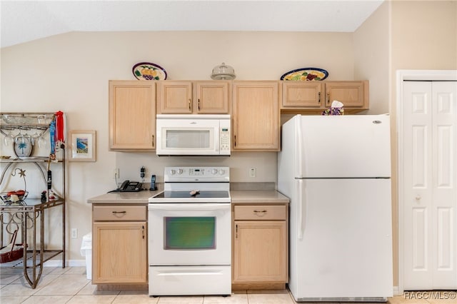 kitchen featuring white appliances, light brown cabinetry, vaulted ceiling, and light tile patterned floors