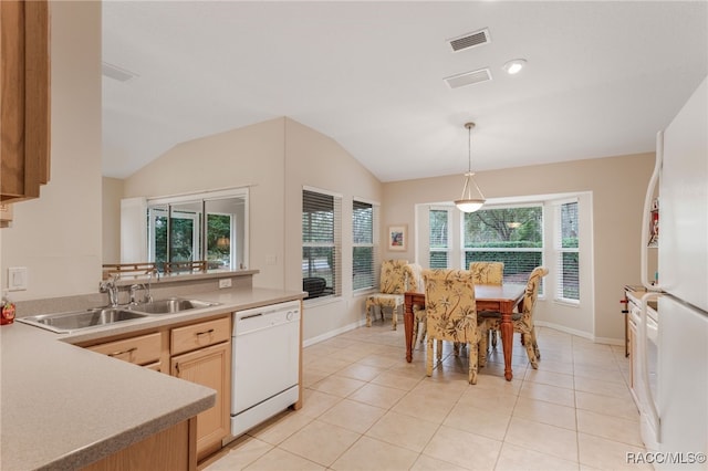 kitchen with lofted ceiling, sink, white appliances, hanging light fixtures, and light brown cabinets