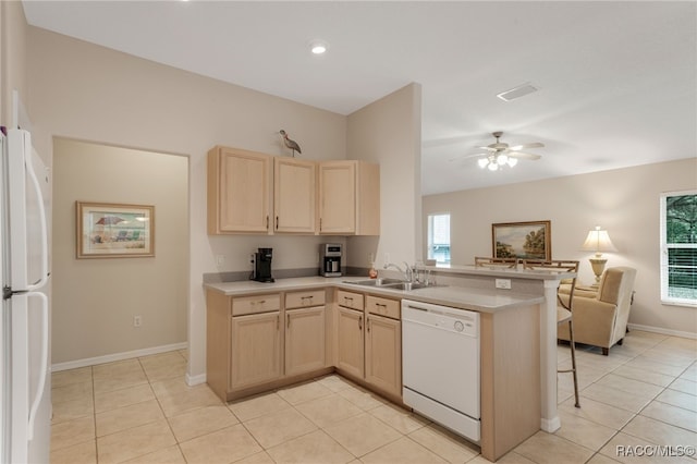 kitchen featuring sink, white appliances, ceiling fan, a kitchen bar, and kitchen peninsula