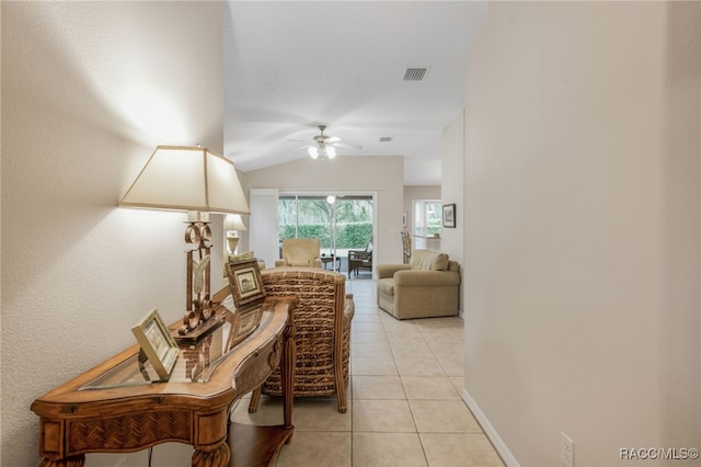 hallway featuring vaulted ceiling and light tile patterned floors