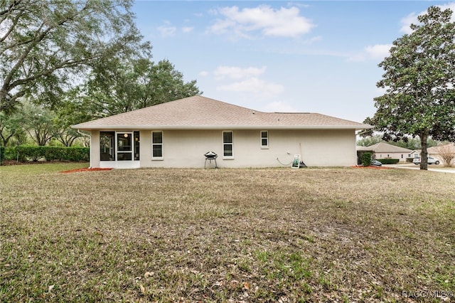 back of property with a sunroom and a yard