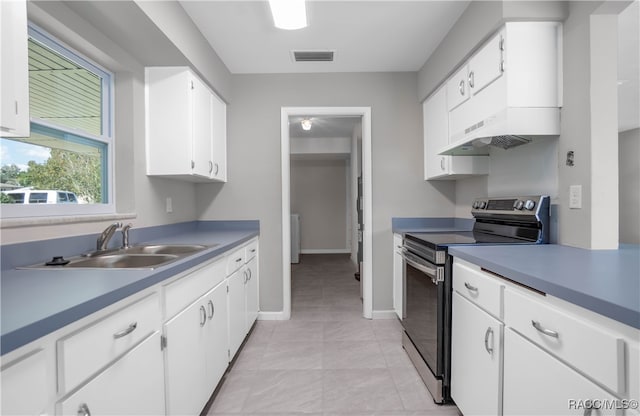 kitchen with extractor fan, sink, light tile patterned floors, white cabinets, and stainless steel electric range oven