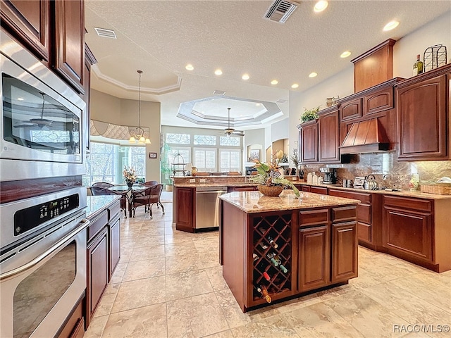 4339 N Canarywood Ter, Beverly Hills, FL 34465 - kitchen with kitchen peninsula, a kitchen island, custom range hood, pendant lighting, and stainless steel appliances