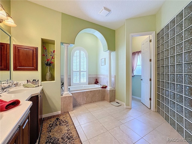 4339 N Canarywood Ter, Beverly Hills, FL 34465 - bathroom with tile patterned floors, vanity, tiled bath, and decorative columns