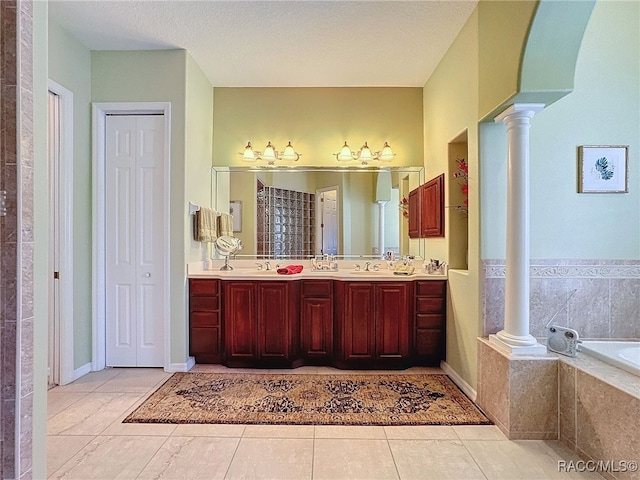 4339 N Canarywood Ter, Beverly Hills, FL 34465 - bathroom with vanity, a relaxing tiled tub, tile patterned floors, and ornate columns