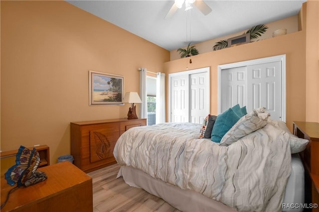 bedroom featuring a ceiling fan, multiple closets, and light wood finished floors