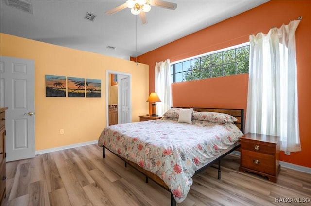bedroom with visible vents, light wood finished floors, and baseboards