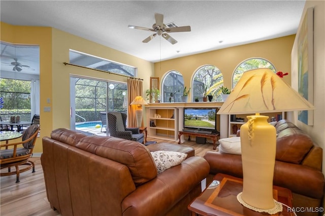 living room featuring wood finished floors, visible vents, and a ceiling fan