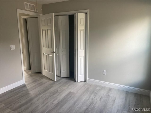 unfurnished bedroom featuring a closet and light wood-type flooring