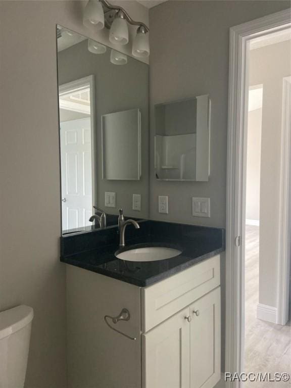 bathroom featuring vanity and toilet