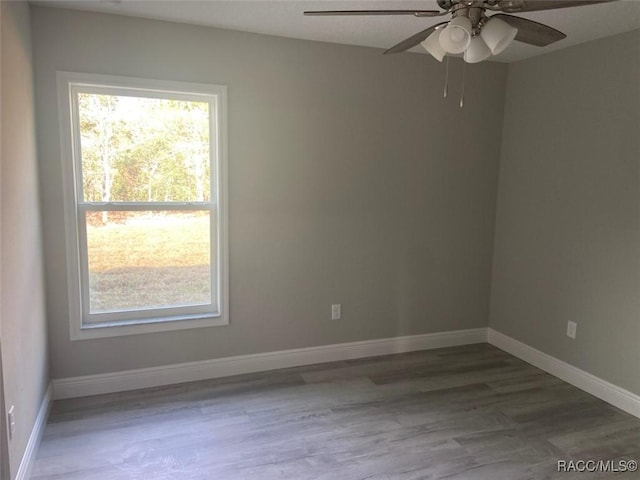 empty room with hardwood / wood-style floors and ceiling fan