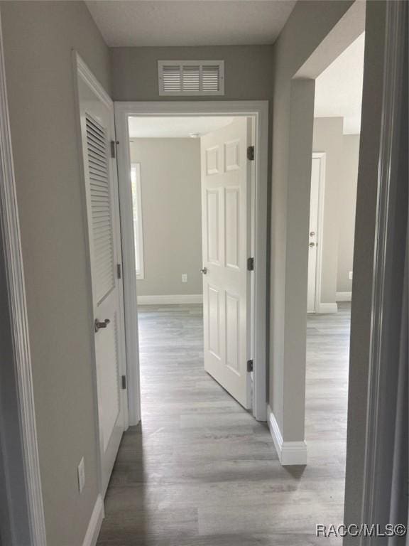 corridor with light hardwood / wood-style floors