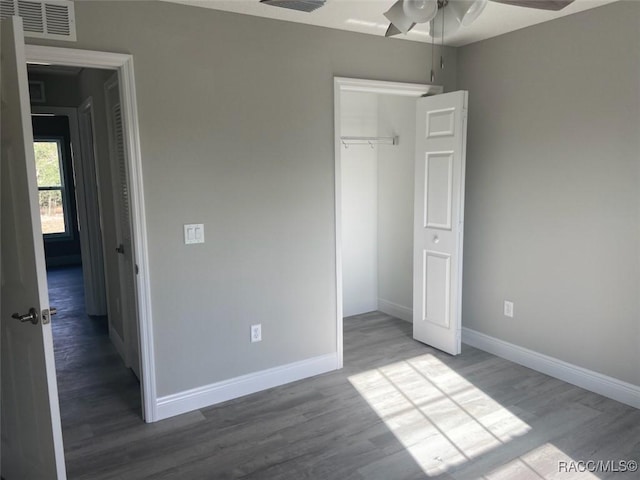 unfurnished bedroom featuring ceiling fan, hardwood / wood-style floors, and a closet